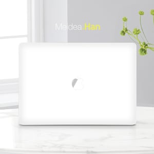 Peut inclure: Un ordinateur portable blanc avec un logo Apple sur le couvercle. L'ordinateur portable est posé sur une surface en marbre blanc.