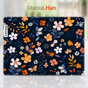 Könnte beinhalten: Eine schwarze Laptop-Haut mit einem Blumenmuster mit orangefarbenen, rosa und weißen Blumen, grünen Blättern und Schmetterlingen. Die Haut hat das Wort "Lenovo" auf der Seite.