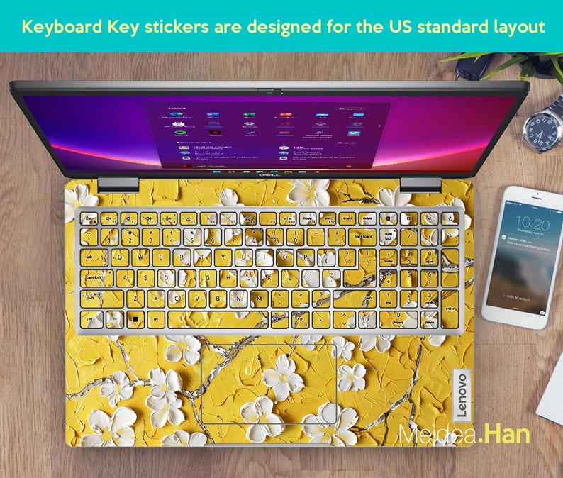 May include: A laptop computer with a yellow and white floral keyboard sticker. The sticker features a floral design with white flowers on a yellow background. The laptop is a Lenovo.