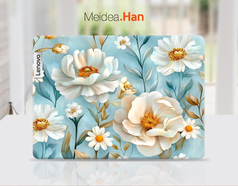 Puede incluir: Una piel para port&aacute;til floral azul y blanca con la palabra "Lenovo" en texto blanco en el lado izquierdo. La piel presenta una variedad de flores blancas con centros amarillos sobre un fondo azul claro.