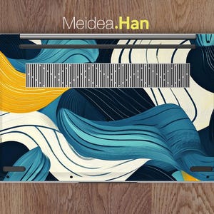 May include: A laptop with a blue, white, and yellow abstract design on the back. The design features swirling lines and shapes.