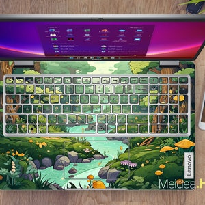 May include: A green and blue laptop skin with a cartoon forest scene and a river. The skin has a white keyboard overlay with green and blue keys. The laptop skin has the text "Lenovo" and "Meidea.Han" on it.