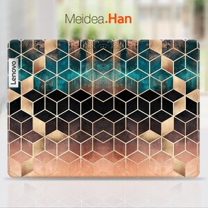 May include: A laptop skin with a geometric pattern of black, gold, and teal cubes. The skin has a gradient effect, fading from teal to gold to pink. The Lenovo logo is visible on the left side of the skin.