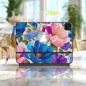Könnte beinhalten: Eine iPad-Hülle und ein Stift mit einem lebendigen Blumenmuster in Blau-, Rosa- und Lilatönen. Die Hülle hat das Apple-Logo und den Text "Meidea.Han". Der Stift hat ein passendes Blumenmuster.