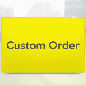 May include: A bright yellow rectangular sign with the words "Custom Order" in dark gray lettering. The sign has rounded corners and is set against a blurred background.