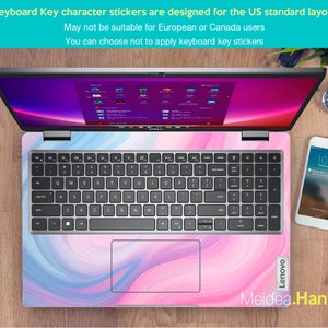 May include: A silver laptop computer with a pink and blue marbled design on the bottom half of the laptop. The keyboard has black keys with white lettering. The laptop is open and the screen is showing a blue and purple background with several icons.