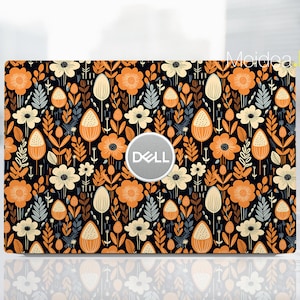 May include: A black laptop skin with a floral pattern in shades of orange, yellow, and white. The Dell logo is visible on the laptop.