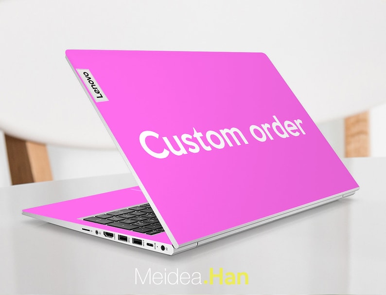 May include: A pink laptop with a white "Custom order" sticker on the lid. The laptop is open and the screen is facing away from the camera. The Lenovo logo is visible on the left side of the lid.