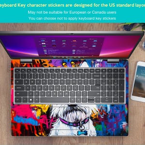 May include: A laptop computer with a colourful graffiti design sticker on the keyboard and touchpad. The sticker features a white dog with a pink collar and a bone charm. The laptop is open and the screen is displaying a desktop with multiple icons.