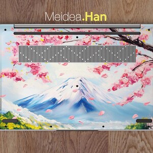 May include: A laptop skin with a painted design of Mount Fuji and cherry blossoms. The design is in shades of pink, blue, and white. The text "Meidea.Han" is printed at the top of the skin.