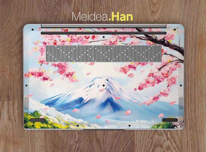 May include: A laptop skin with a painted design of Mount Fuji and cherry blossoms. The design is in shades of pink, blue, and white. The text "Meidea.Han" is printed at the top of the skin.