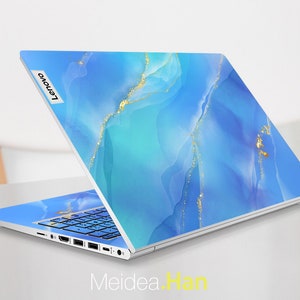 May include: A silver laptop with a blue and gold abstract design on the lid. The Lenovo logo is visible on the lid.