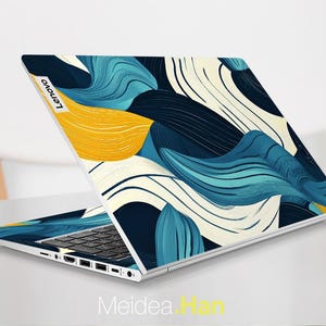 May include: A laptop computer with a blue, yellow, and white abstract design on the lid. The Lenovo logo is visible on the lid.
