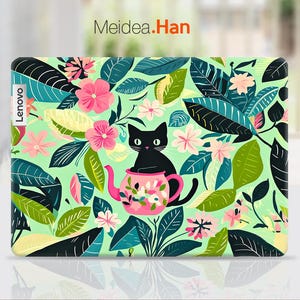 Può includere: Una pelle per laptop floreale verde, nera e rosa con un gatto nero seduto in una teiera rosa. Il testo "Lenovo" è sul lato sinistro della pelle.