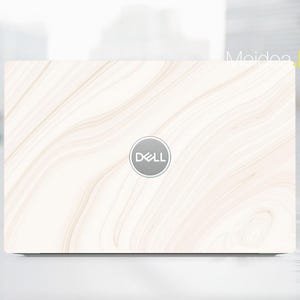 May include: A Dell laptop with a white and beige marble-patterned skin. The laptop has a silver Dell logo in the center. The skin has a flowing, organic design, giving the laptop a natural, elegant look. The text "Meidea Han" is visible on the right side.