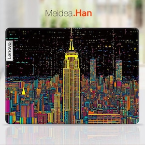 Pode incluir: Uma capa para laptop com um design de cidade pixelado e colorido que apresenta o Empire State Building. A capa tem a palavra "Lenovo" impressa no lado esquerdo.