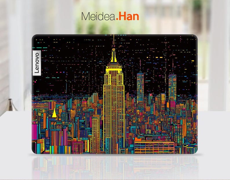 Pode incluir: Uma capa para laptop com um design de cidade pixelado e colorido que apresenta o Empire State Building. A capa tem a palavra "Lenovo" impressa no lado esquerdo.