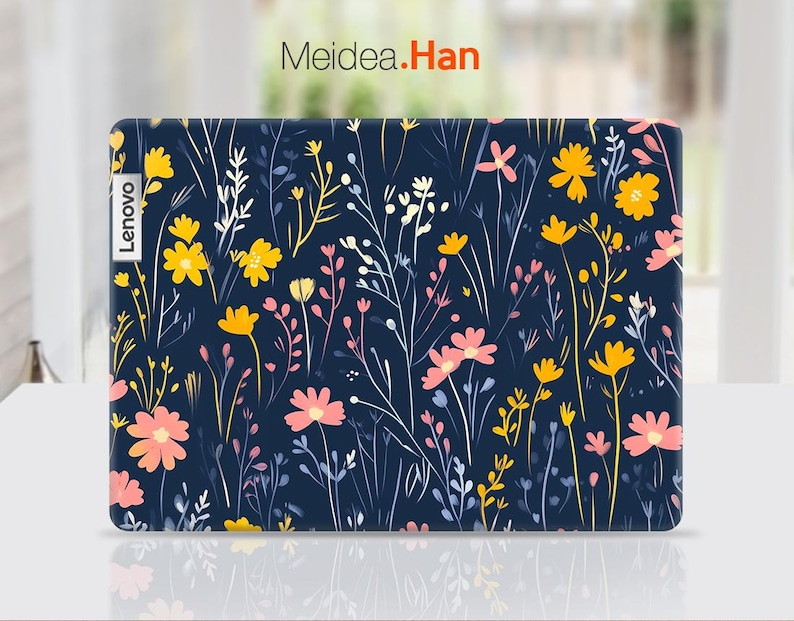 May include: A blue laptop skin with a floral pattern featuring pink and yellow flowers on a dark blue background. The skin has the word "Lenovo" printed on the left side.