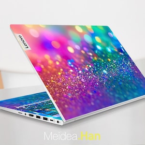 May include: A laptop computer with a colorful glitter design on the lid. The design features a rainbow of colors, including pink, purple, blue, green, and yellow. The Lenovo logo is visible on the lid.