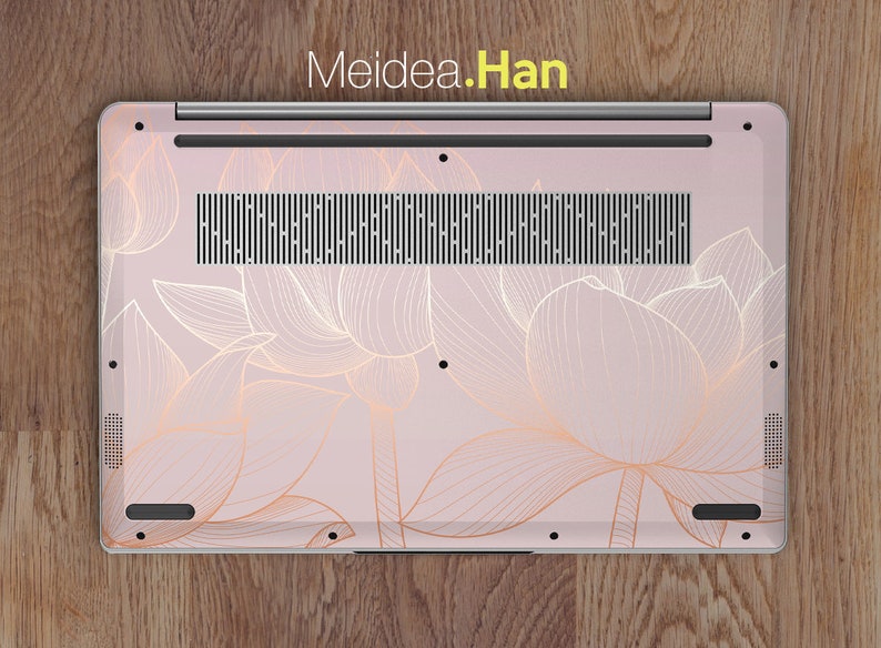 Puede incluir: Una funda para port&aacute;til con un fondo rosa claro y un dise&ntilde;o floral dorado. La funda cubre la parte inferior del port&aacute;til e incluye el texto "Meidea.Han" en la parte superior. El dise&ntilde;o floral es un delicado dibujo lineal de flores de loto.