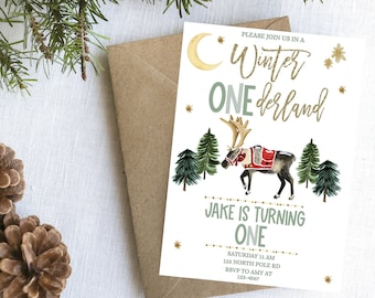 May include: A white invitation card with a gold glitter design. The card features a reindeer with a red and white saddle, surrounded by green pine trees. The text on the card reads "Please join us in a Winter Wonderland, Jake is turning one, Saturday 11 AM, 123 North Pole Rd, RSVP to Amy at 123-4567".