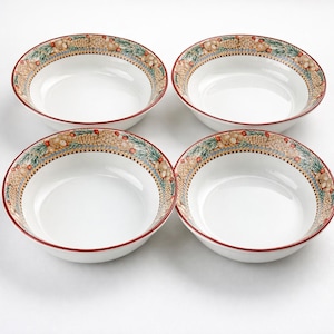 May include: Four white ceramic bowls with a decorative border featuring a pattern of leaves, berries, and tan and gold accents. The rims are trimmed with a thin red line. The bowls are arranged on a white surface.