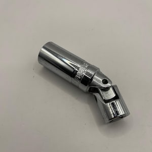 May include: A chrome-plated, adjustable spark plug socket wrench. The wrench is angled and features a swivel head for accessing hard-to-reach areas. The word "POWER" is visible on the wrench.