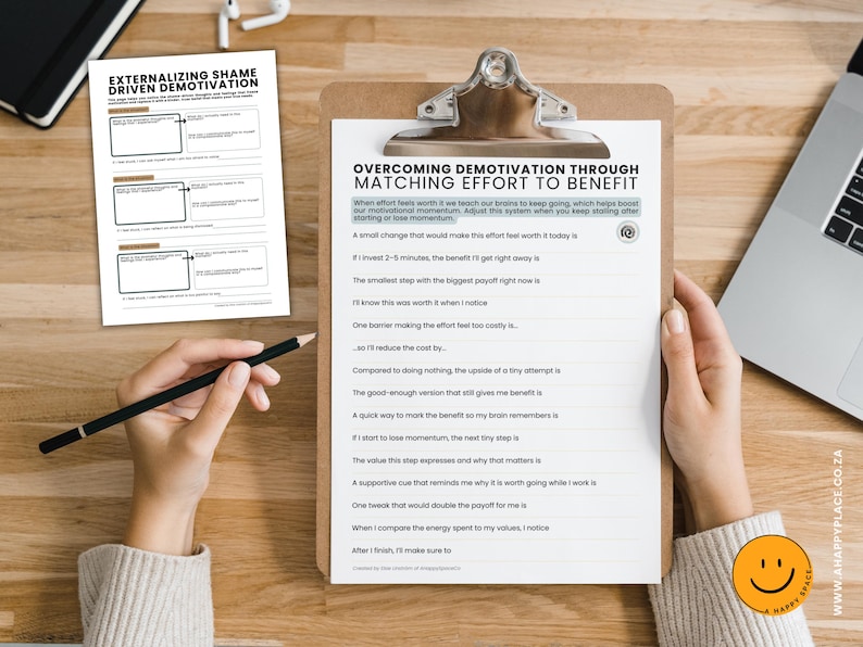 Puede incluir: Un portapapeles con el texto "OVERCOMING DEMOTIVATION THROUGH MATCHING EFFORT TO BENEFIT" y una hoja de trabajo titulada "EXTERNALIZING SHAME DRIVEN DEMOTIVATION". Una mano sostiene un l&aacute;piz y se ve un port&aacute;til.