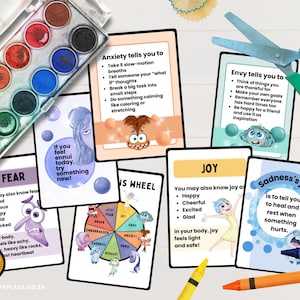 May include: A watercolor paint set with various colors and cards with text about emotions. The cards feature characters and phrases like "Anxiety tells you to" and "Joy". Scissors and crayons are also visible.