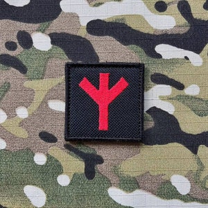 May include: A black patch with a red symbol resembling a stylized tree or a Y shape.