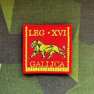 May include: A red and gold embroidered patch with a lion and the text "LEG XVI GALLICA".