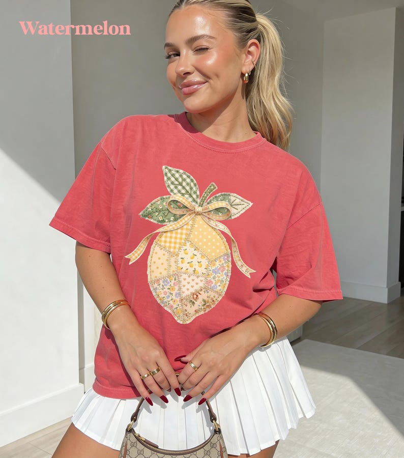 May include: A red t-shirt with a patchwork lemon design. The lemon features a yellow and floral pattern with green leaves and a bow. The word "Watermelon" is printed at the top of the image.
