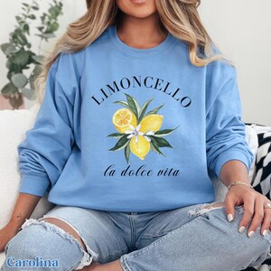 May include: A light blue sweatshirt with a graphic of lemons and the text "Limoncello la dolce vita".