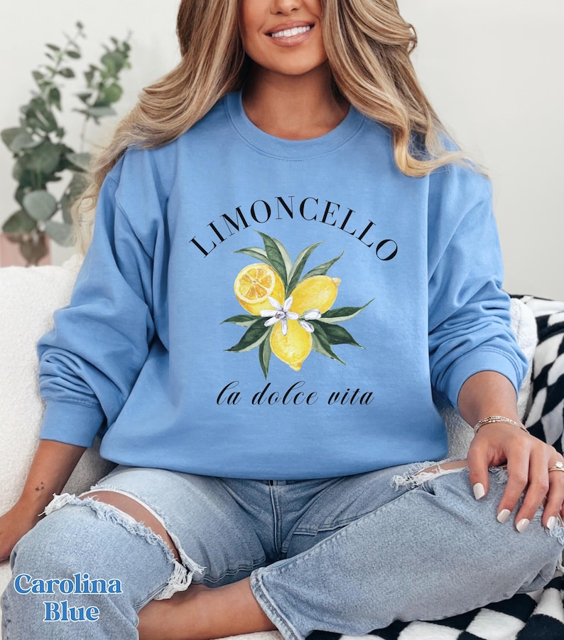 May include: A light blue sweatshirt with a graphic of lemons and the text "Limoncello la dolce vita".