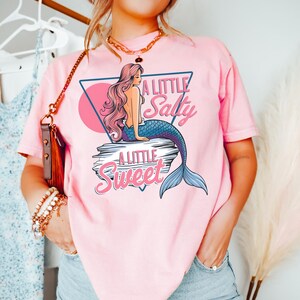 salty mermaid shirt with a retro summer vibe of mermaid that says A Little Salty A Little Sweet on a Comfort Colors shirt in the color blossom blossom pink