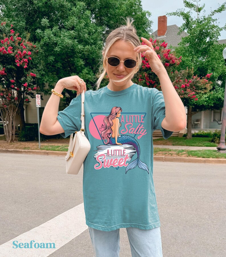 salty mermaid shirt with a retro summer vibe of mermaid that says A Little Salty A Little Sweet on a Comfort Colors shirt in the color blossom seafoam