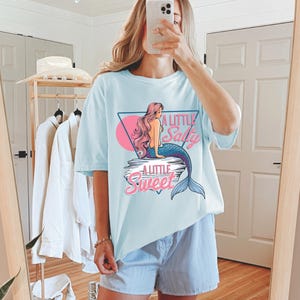 salty mermaid shirt with a retro summer vibe of mermaid that says A Little Salty A Little Sweet on a Comfort Colors shirt in the color blossom chambray light blue
