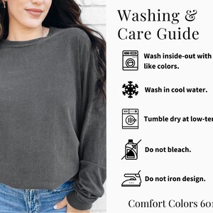 May include: A charcoal gray long-sleeve sweatshirt with a crew neck. The image includes a washing and care guide with instructions: wash inside-out with like colors, wash in cool water, tumble dry at low-temp, do not bleach, and do not iron design.
