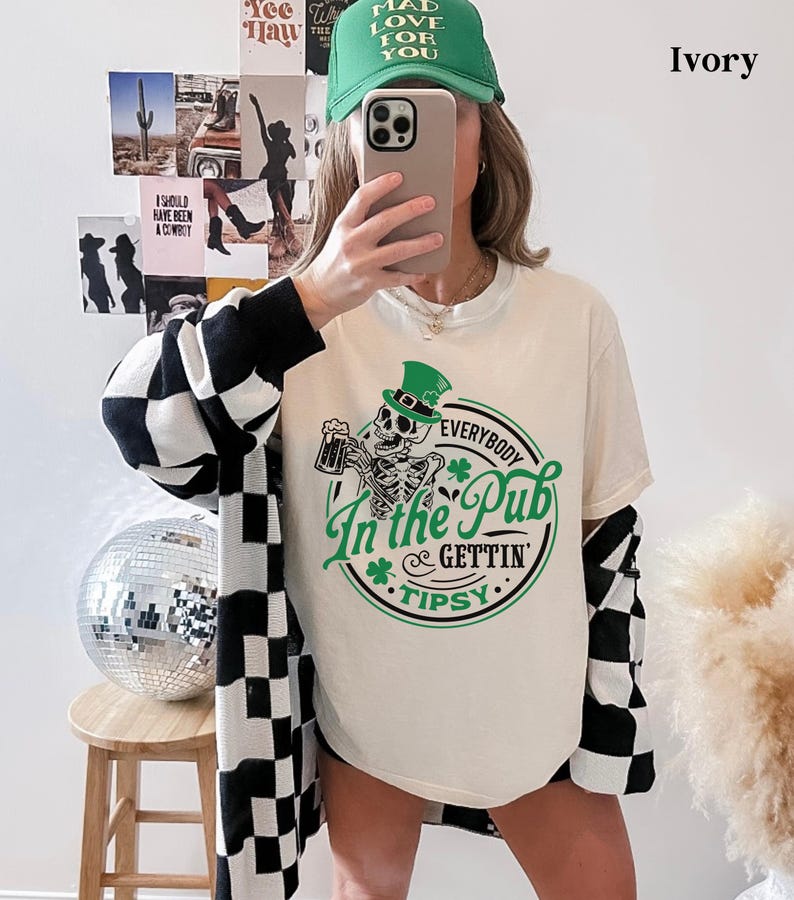 skeleton pub crawl shirt for your St. Patrick's Day party that has a skeleton holding a beer wearing a green Leprechaun hat with shamrocks saying Everybody in the Pub Gettin' Tipsy on a Comfort Colors shirt in the color ivory