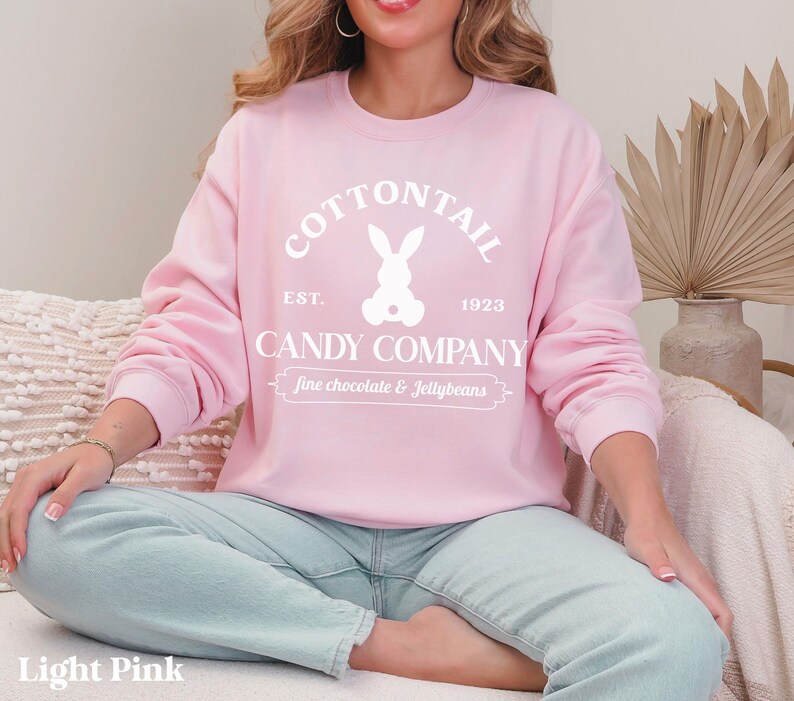 bunny sweatshirt for Easter that has a pastel bunny that says Cottontail Candy Company on a spring sweatshirt in the color light pink