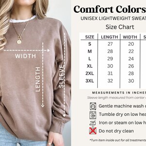 Puede incluir: Una sudadera unisex ligera Comfort Colors 1466 en un color neutro. La imagen incluye una tabla de tallas con medidas en pulgadas para largo, ancho y largo de manga, que van desde la talla S hasta la 3XL. Tambi&eacute;n se proporcionan instrucciones de lavado.