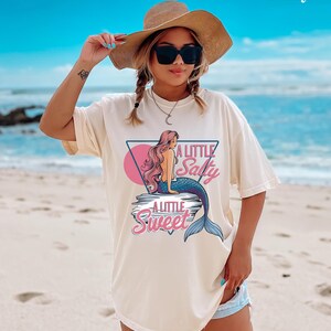 salty mermaid shirt with a retro summer vibe of mermaid that says A Little Salty A Little Sweet on a Comfort Colors shirt in the color blossom ivory
