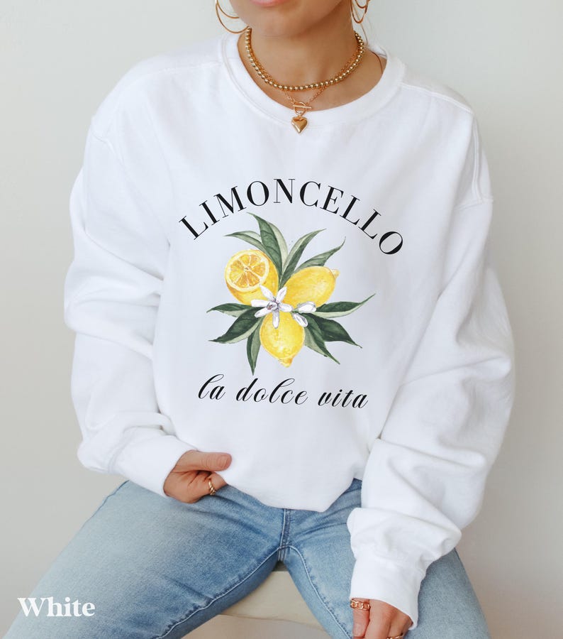 May include: White sweatshirt with a graphic of lemons and the text "Limoncello la dolce vita".