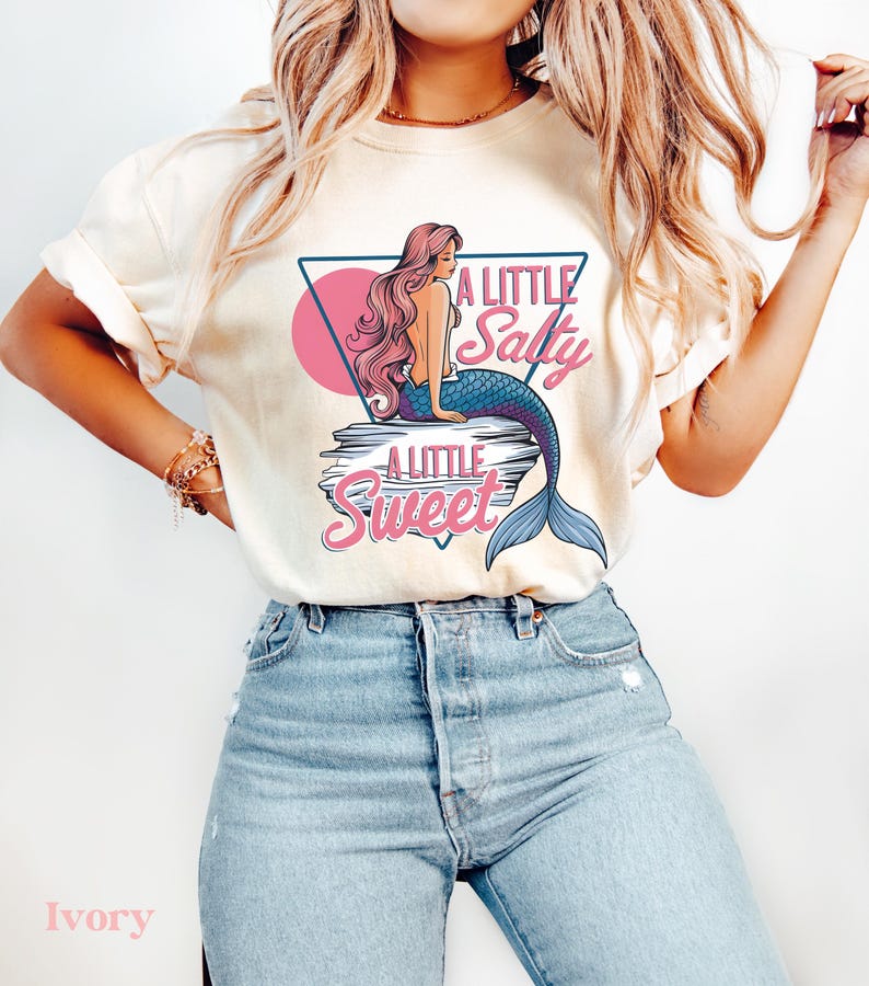 salty mermaid shirt with a retro summer vibe of mermaid that says A Little Salty A Little Sweet on a Comfort Colors shirt in the color blossom ivory