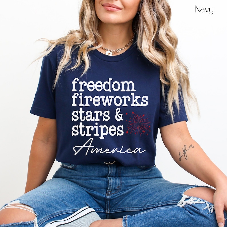 America fourth of July shirt that says freedom fireworks stars & stripes America with a firework on a Bella Canvas shirt in the color navy blue