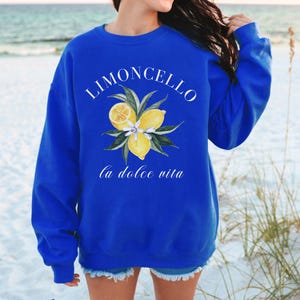 May include: A royal blue sweatshirt with the text "Limoncello la dolce vita" and a graphic of lemons and leaves.