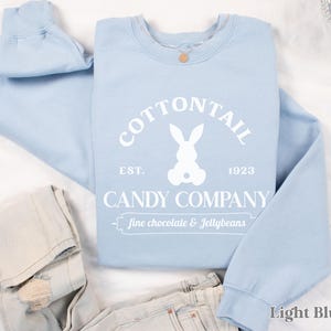 bunny sweatshirt for Easter that has a pastel bunny that says Cottontail Candy Company on a spring sweatshirt in the color light blue