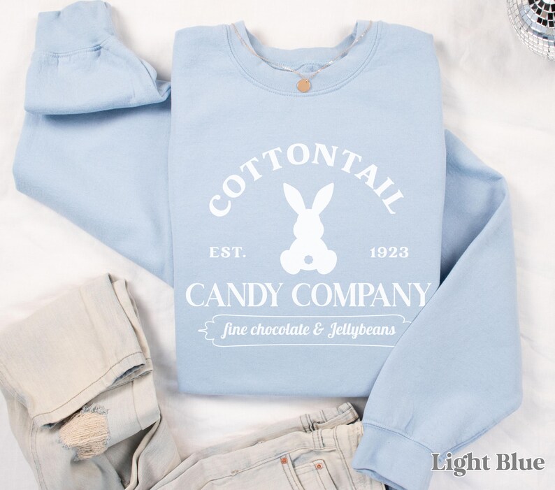 bunny sweatshirt for Easter that has a pastel bunny that says Cottontail Candy Company on a spring sweatshirt in the color light blue