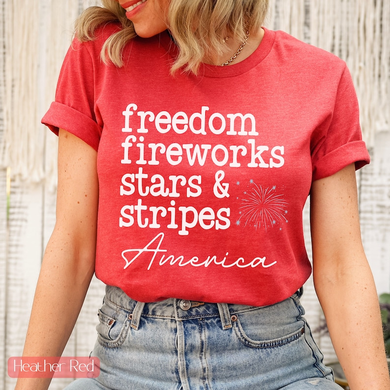 America fourth of July shirt that says freedom fireworks stars & stripes America with a firework on a Bella Canvas shirt in the color heather red