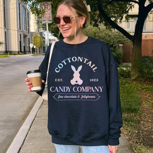 bunny sweatshirt for Easter that has a pastel bunny that says Cottontail Candy Company on a spring sweatshirt in the color navy blue
